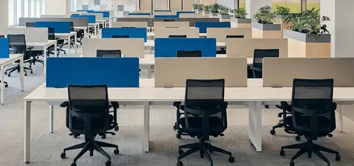 Modern open-plan office space featuring clean workstations, ergonomic chairs, and sanitized carpets provided by professional office cleaning services in Sarasota, FL.